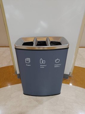 Alışveriş merkezinde farklı simgeleri olan geri dönüşüm kutusu, çöpü ayırmak için simgesi olan çöp kutusu.