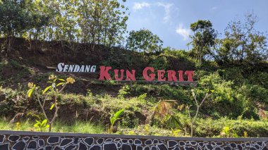 SRAGEN, İNDONEZYA AĞUSTOS 14, 2022: SENDANG KUN GERIT adlı doğal bir bahar banyosunun işareti yamaçta yer almaktadır..