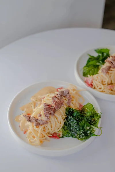 İki porsiyon Rose Pasta Spagetti 'nin dikey ya da portresi. Biri odaklanmış, diğeri bulanık değil.