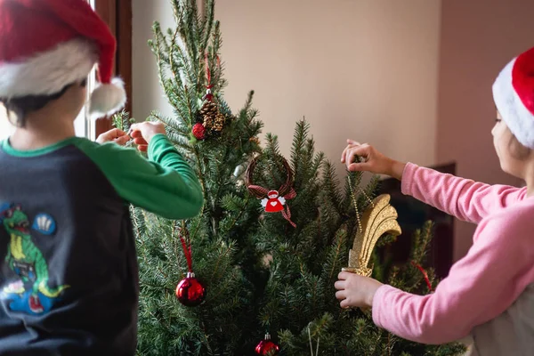 Duas Meninas Pijama Chapéus Papai Noel Decorando Árvore Natal Sua — Fotografia de Stock