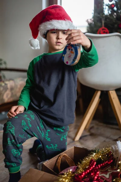 Noel Baba Şapkası Takan Pijamalı Bir Kız Noel Süsleriyle Kutudan — Stok fotoğraf