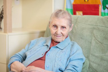 Büyükanne portresi, evde oturan yaşlı bir kadın, 90 yaşında, yaşlı, yüzünde kırışıklıklar var..