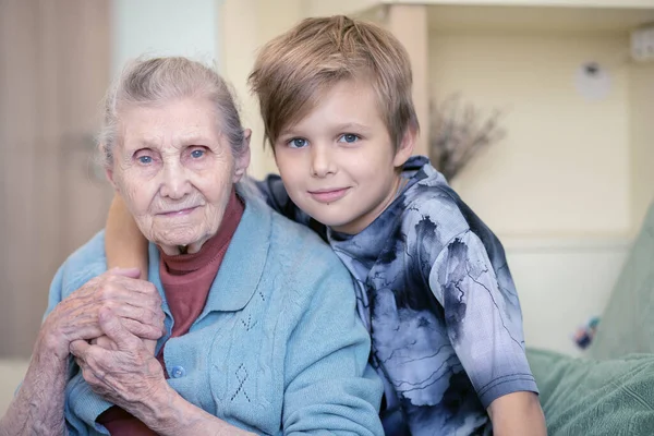 Portrait Grandmother Her Grandson Old Woman Sits Sofa Boy Hugs — Stock Photo, Image