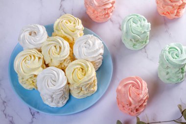 Elma ve nane ile yapılmış ev yapımı marşmelovlar (zephyr) ile düz bir zeminde uzanmış, arkaplanda tatlı, havadar, pudra şekeri serpiştirilmiş kekler, güzel şenlikli arka plan.