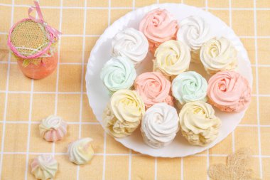 Elma ve nane ile yapılmış ev yapımı marşmelovlar (zephyr) ile düz bir zeminde uzanmış, arkaplanda tatlı, havadar, pudra şekeri serpiştirilmiş kekler, güzel şenlikli arka plan.