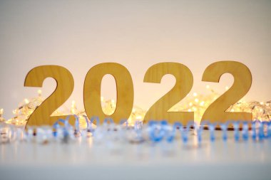 Yeni yıl 2022, beyaz bir masada tahta numaralar şeritli, yeni yıl ve Noel arkaplanlı, sembollü ve yılın işaretiyle.