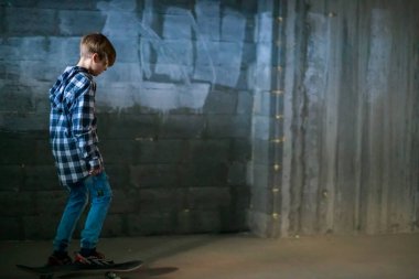 Kaykaydaki sevimli çocuk, çocuk kaykay sürmeyi öğreniyor..