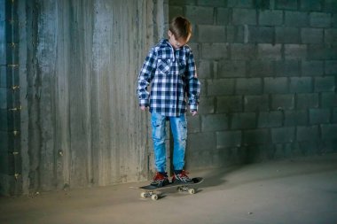 Kaykaydaki sevimli çocuk, çocuk kaykay sürmeyi öğreniyor..