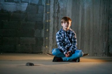 Kaykaydaki sevimli çocuk, çocuk kaykay sürmeyi öğreniyor..