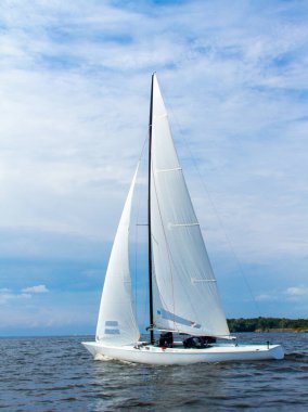 Su, deniz ve nehir üzerinde beyaz yelkenli bir yat, mavi gökyüzü, güzel bir arka plan..