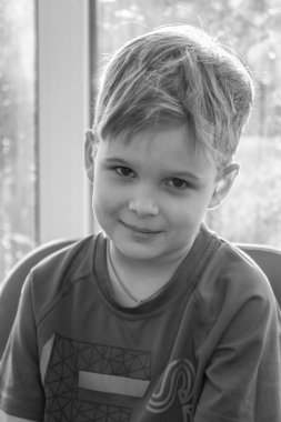 Sevimli bir çocuğun siyah beyaz portresi, çocuk gülümsüyor, çocuğun yüzünde neşe.