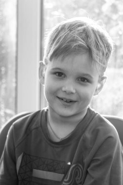 Sevimli bir çocuğun siyah beyaz portresi, çocuk gülümsüyor, çocuğun yüzünde neşe.