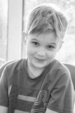 Sevimli bir çocuğun siyah beyaz portresi, çocuk gülümsüyor, çocuğun yüzünde neşe.