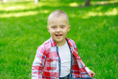 Yazın parkta Down sendromlu bir çocuk, mutlu bir çocuk güler..