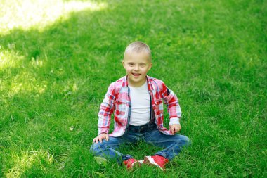 Yazın parkta Down sendromlu bir çocuk, mutlu bir çocuk güler..