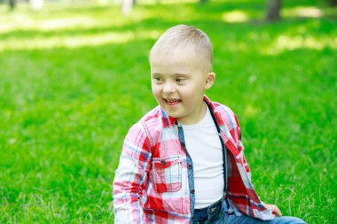 Yazın parkta Down sendromlu bir çocuk, mutlu bir çocuk güler..