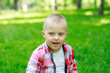 Yazın parkta Down sendromlu bir çocuk, mutlu bir çocuk güler..