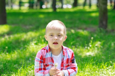 Yazın parkta Down sendromlu bir çocuk, mutlu bir çocuk güler..