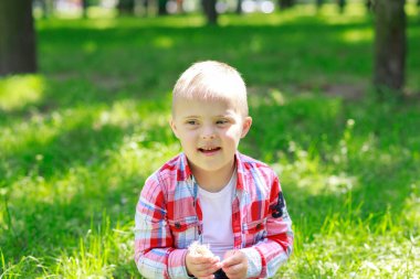 Yazın parkta Down sendromlu bir çocuk, mutlu bir çocuk güler..