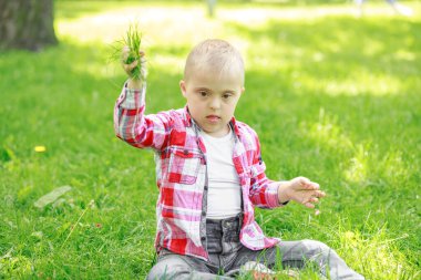 Yazın parkta Down sendromlu bir çocuk, mutlu bir çocuk güler..