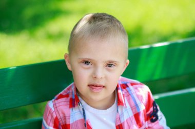 Yazın parkta Down sendromlu bir çocuk, mutlu bir çocuk güler..