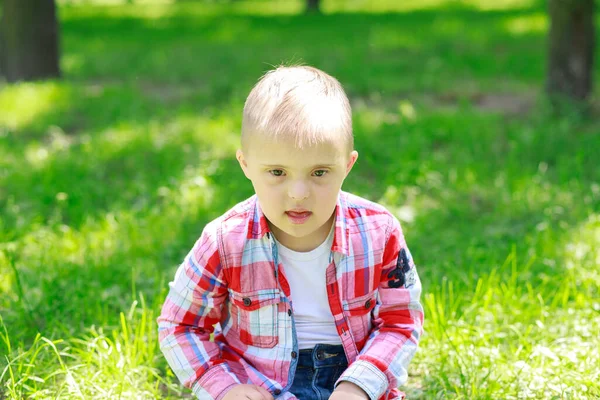 Yazın parkta Down sendromlu bir çocuk, mutlu bir çocuk güler..