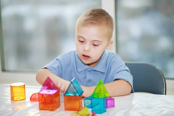 Хлопчик Синдромом Дауна Грає Геометричними Фігурами Пластиковим Конструктором Трисономією Типу — стокове фото