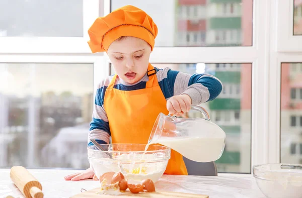 Мальчик Синдромом Дауна Готовит Тесто Муки Молока Кухне Трисономия Типа — стоковое фото