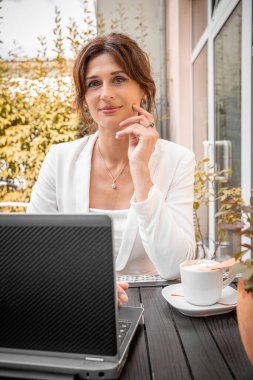 Young woman working remotely using laptop, online communication, work-life balance.
