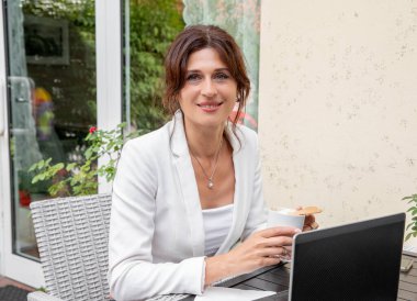 Young woman working remotely using laptop, online communication, work-life balance.