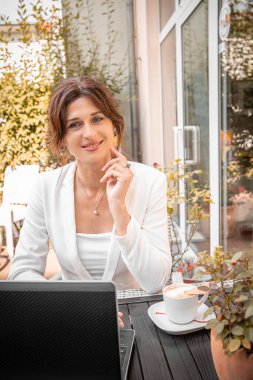 Young woman working remotely using laptop, online communication, work-life balance.