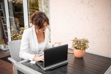 Young woman working remotely using laptop, online communication, work-life balance.