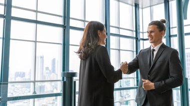 İki yönetici, şehir manzarası olan bir terasta yeni bir proje hakkında gayri resmi bir konuşma yapıyorlar. İş dünyası liderleri yeşil bir binada rahatlatıcı atmosfer altında fikir alışverişinde bulunurlar. Skylines arkaplanı