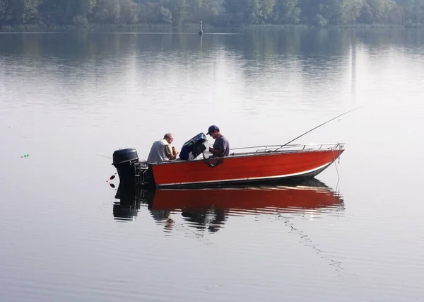 Fishermen in a boat on the lower lake formed by the river Mincio.in Mantua, Italy.