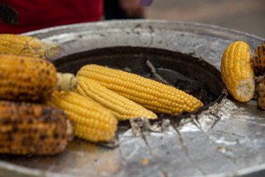 Izgarada kızarmış mısırlar, servis için hazır. Kızartılmış ve pişmiş mısır satılıyor. Yüksek kalite fotoğraf