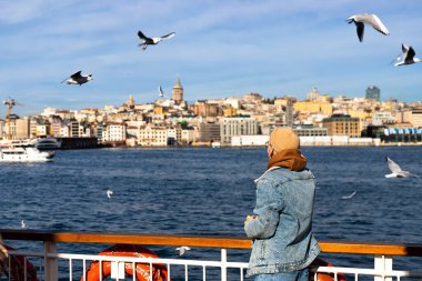 Genç turistler feribotta martılara yemek veriyor, turistik aktiviteler yapıyor. Yüksek kalite fotoğraf