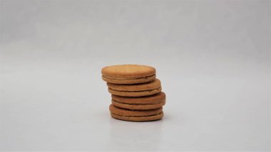 Beyaz arka planda izole edilmiş fıstık ezmesiyle dolu kepekli bisküviler.