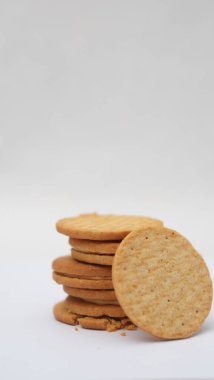 Beyaz arka planda izole edilmiş fıstık ezmesiyle dolu kepekli bisküviler.