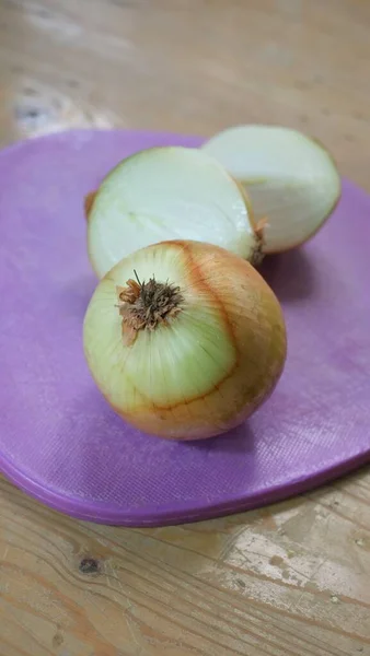 Cebolla Fresca Sobre Tabla Cortar Púrpura Sobre Fondo Madera —  Fotos de Stock