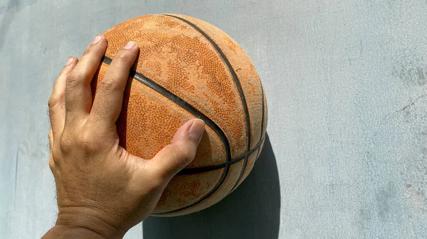 Basketball ball hold by man\'s hand