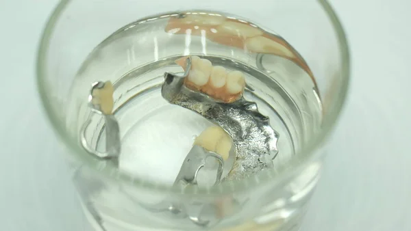 False tooth in a glass of water.