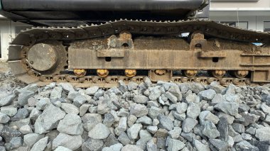 İnşaat alanındaki çakıl taşları üzerinde kazıcı