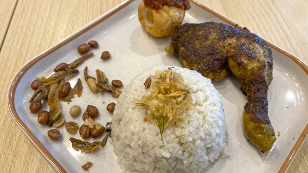 椰子米 Nasi Lemak 与烤鸡 煮熟的鸡蛋 炸鱼和炸花生一起食用 — 图库照片