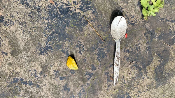 水泥地面上的塑料勺子形式的垃圾 — 图库照片