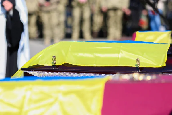 ポルタヴァ ウクライナ 2022年3月17日 葬儀中にウクライナへのロシアの攻撃の犠牲者とウクライナの旗で覆われた赤い木製の棺 — ストック写真