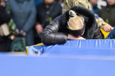 POLTAVA, UKRAINE - 28 Mart 2022 'de mezarın yanındaki meydanda, Ukrayna Silahlı Kuvvetleri' nin Ukrayna-Rusya savaşı sırasında ölen askeri oğlunun yasını tutan bir kadın