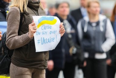 POLTAVA, UKRAINE - 31 Mart 2022: Bir kadın Ukrayna semalarında Ukraynalıların Ukrayna semalarını kapatma eylemleri sırasında gökyüzünün kapatılmasını destekleyen bir poster tutuyor.