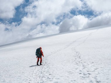 Buzula tırmanan bir turist. Karlı dağlarda kış yürüyüşü. Aşırı eğlence ve dağ turizmi.