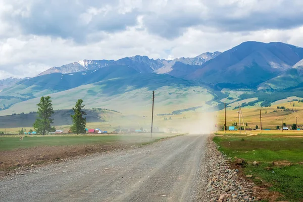 Soft focus. Dust storm over the road in the countryside against the background of mountains.