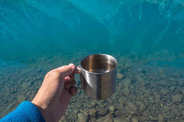 빙하의 호수에머그어 넣었습니다 음료수를 여행자들이 마시는 잡는다 산속의 호수에서 식수를 — 스톡 사진